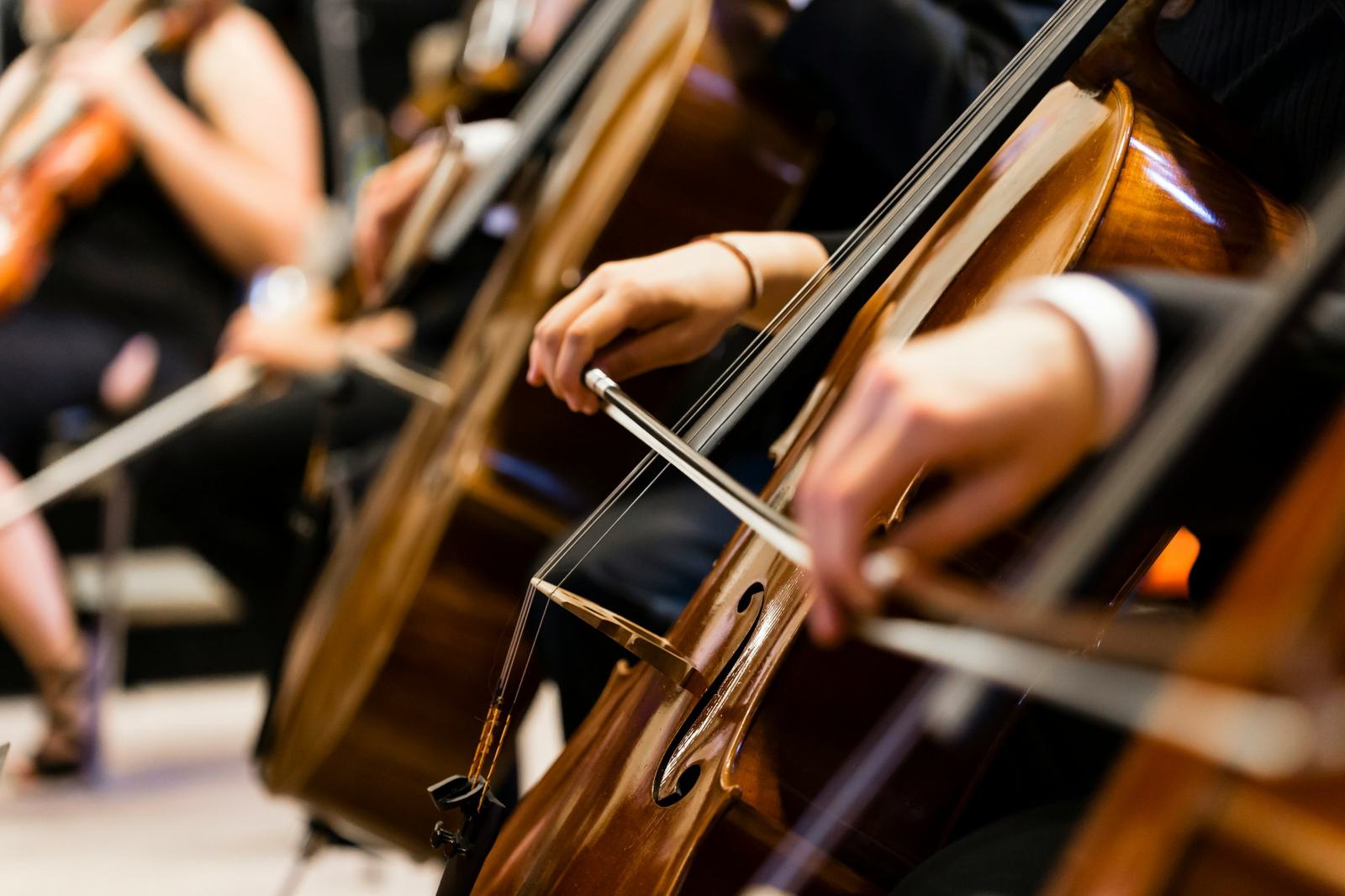 Mãos de violoncelistas durante um concerto de orquestra