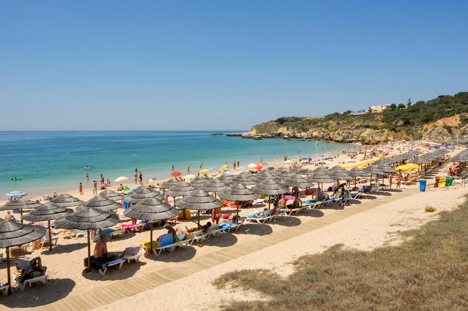 Praia com chapéus de palha e mar azul perto de Albufeira