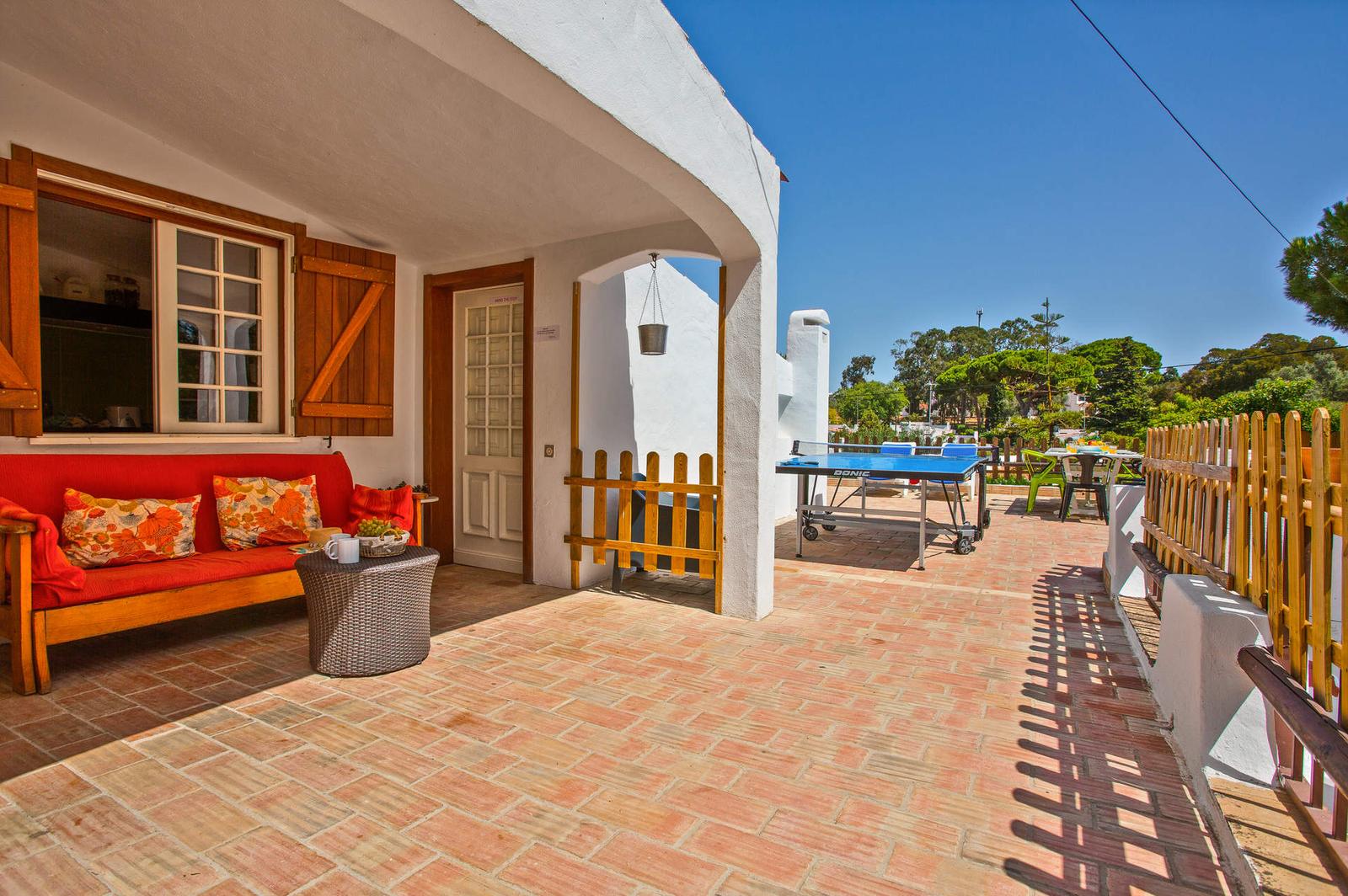 Alpendre com sofá e terraço com ténis de mesa da Villa Namibe