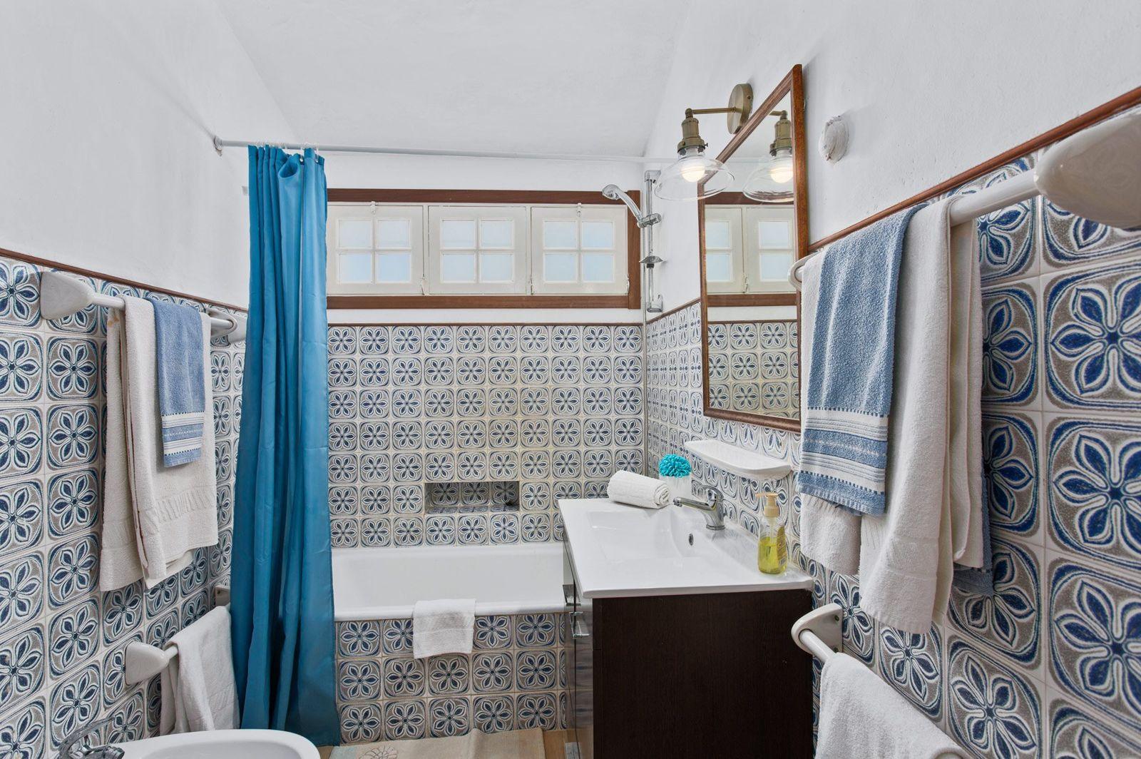 Casa de banho com banheira e azulejos azuis
