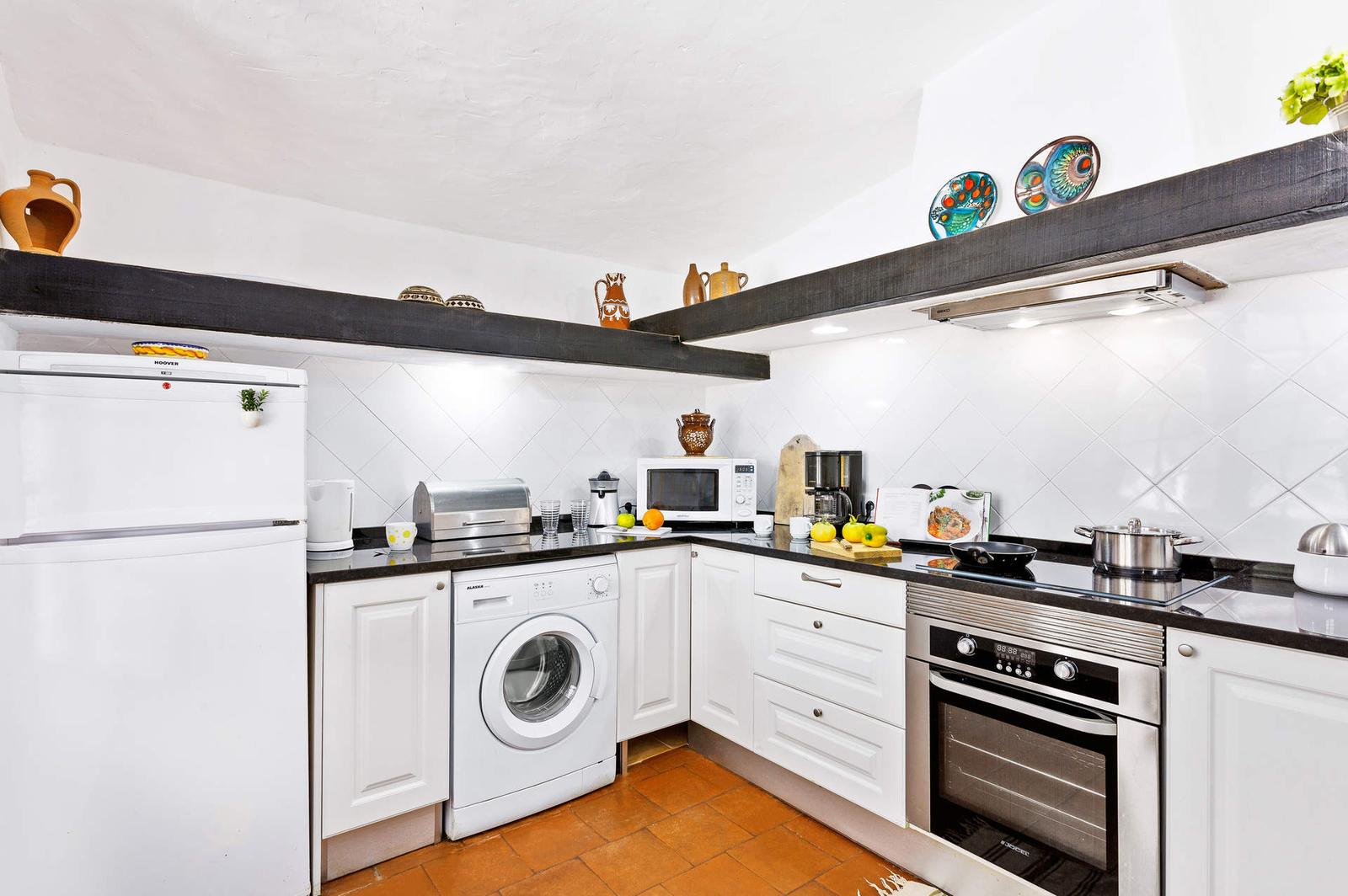 Cozinha equipada com forno, placa e máquina de lavar roupa