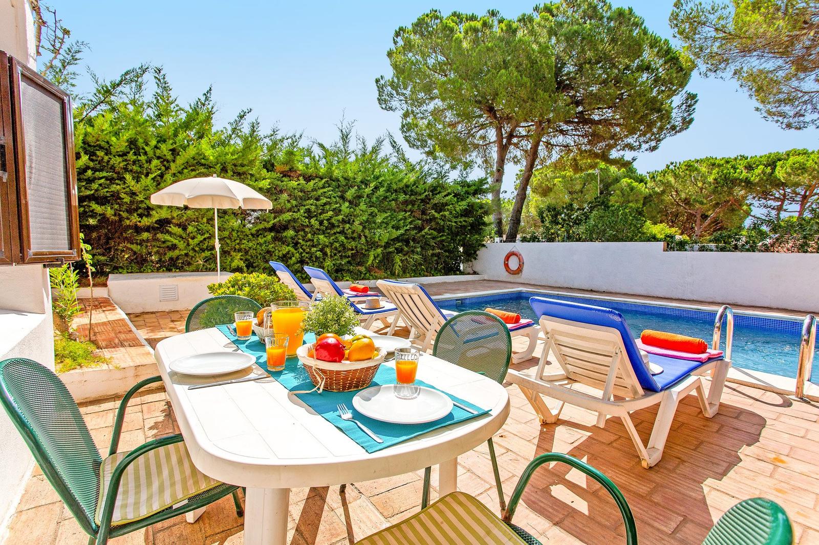 Mesa posta junto à piscina privada da Villa Simão