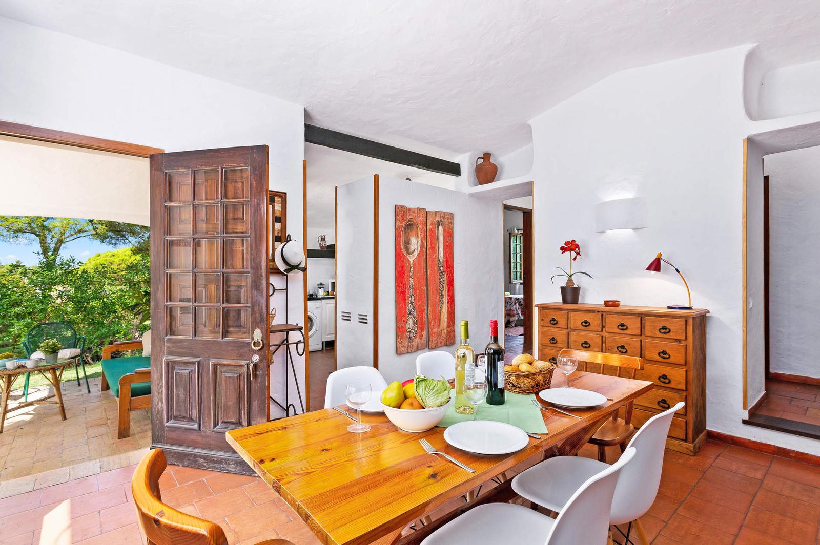Mesa de jantar com porta aberta para o alpendre e o jardim